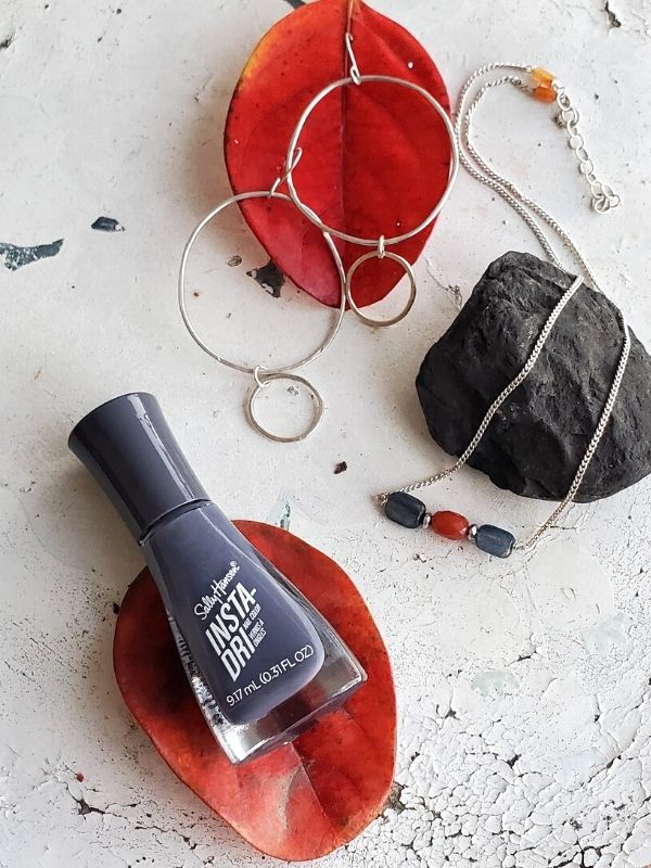 silver earrings, necklace, nail polish displayed